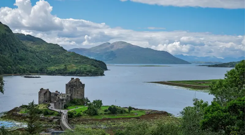 Eilean Donan Castle set among Highland hills and a wide sea loch