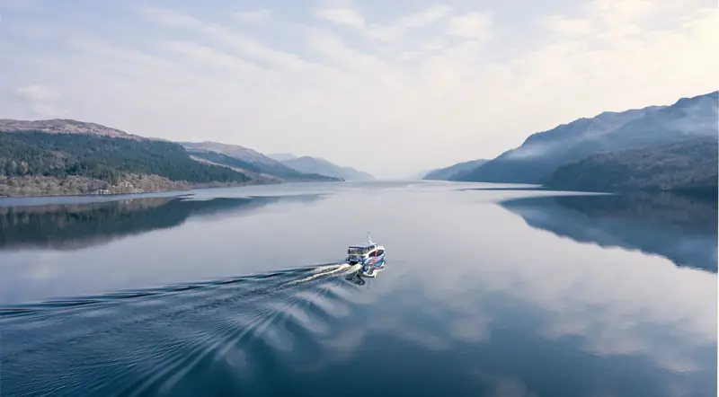 A cruise boat on the calm dark water of Loch Ness